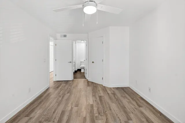 a view of a room with wooden floor and a window