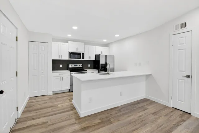 a kitchen with stainless steel appliances a sink and a refrigerator