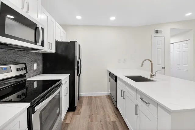 a kitchen with stainless steel appliances granite countertop a sink and a stove