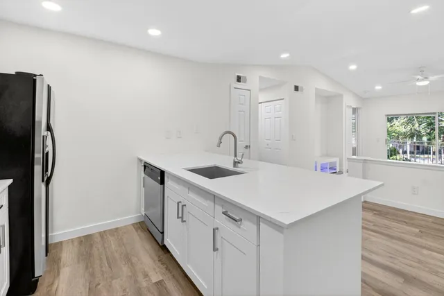 a kitchen with stainless steel appliances a sink and a refrigerator