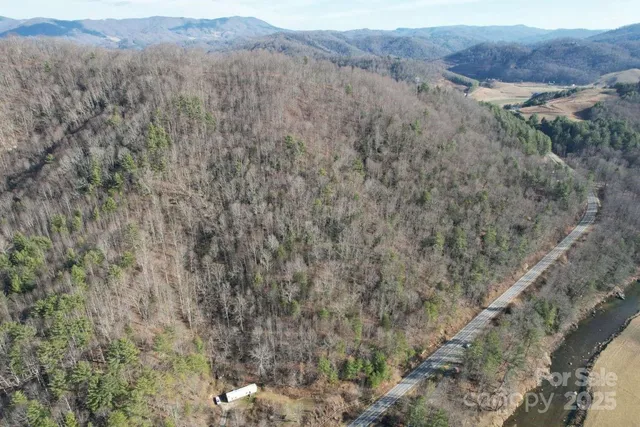 a view of a dry field with trees in the background
