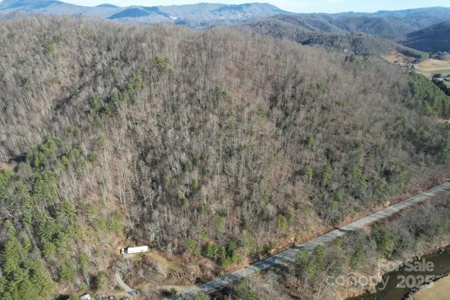 a view of a dry field with mountains in the background