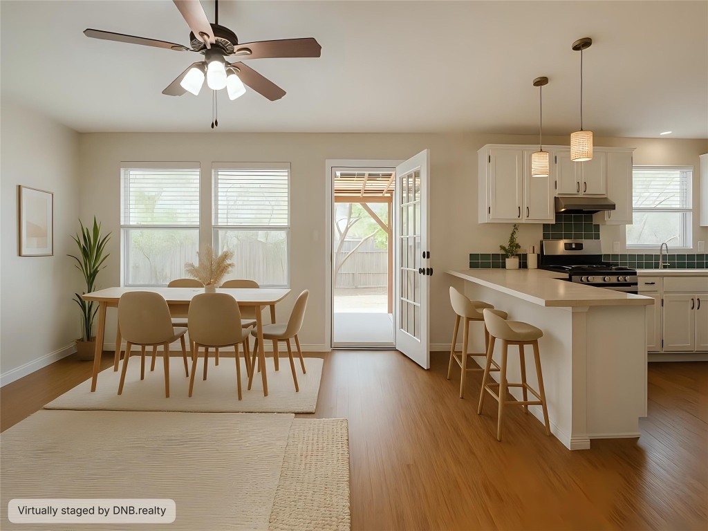 1301 Lipan Trail Austin, TX 78733 - Photo 25 of 39 Kitchen with a breakfast bar area, light countertops, stainless steel gas stove, pendant lighting, and a peninsula