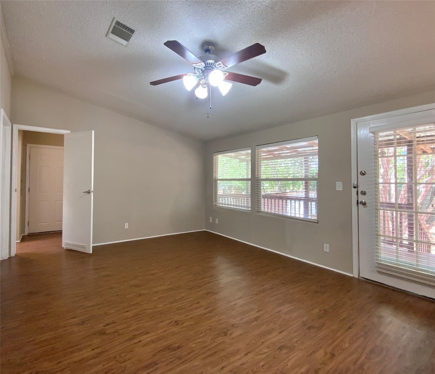 1301 Lipan Trail Austin, TX 78733 - Photo 27 of 39 Unfurnished room featuring dark wood-style floors, a textured ceiling, lofted ceiling, and a ceiling fan