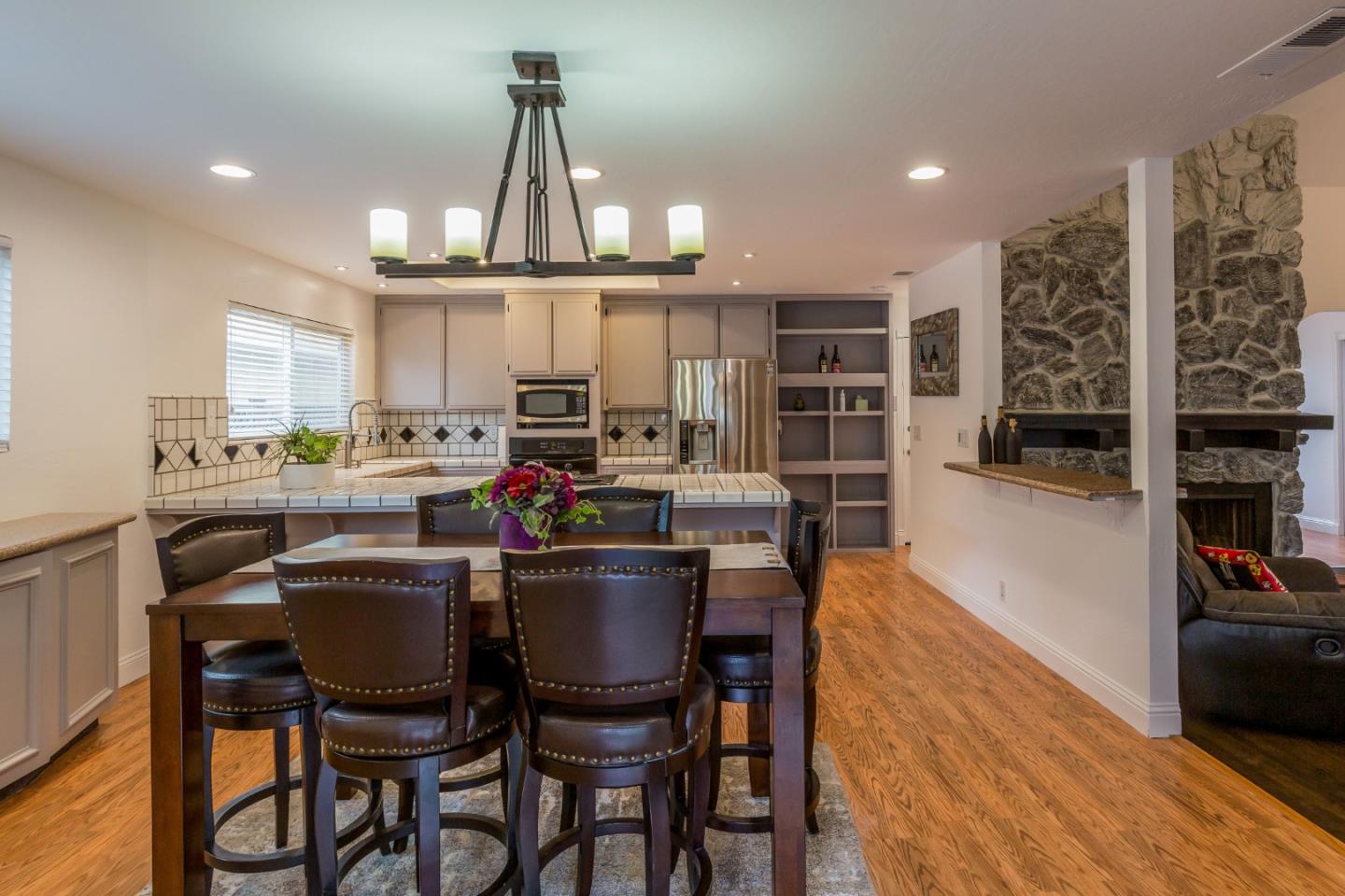 843 Ramona Way Gilroy, CA 95020 - Photo 12 of 26 a dining room with stainless steel appliances a dining table chairs and kitchen view