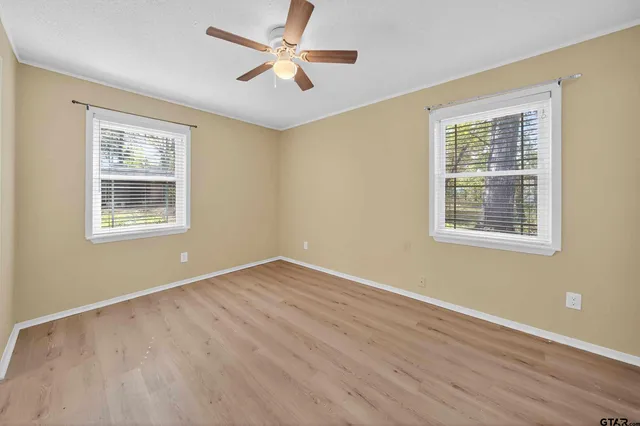 a view of a hallway with wooden floor and closet