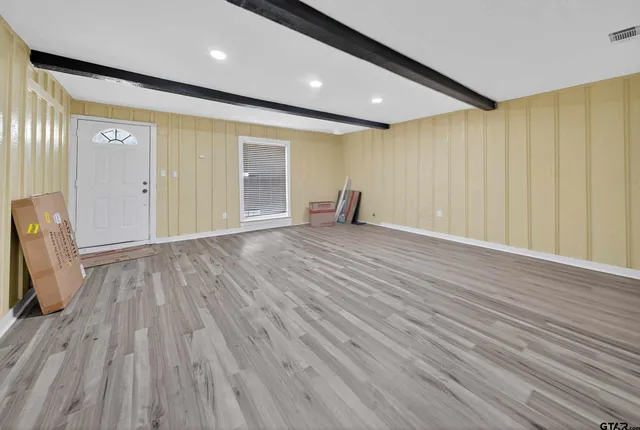 an empty room with wooden floor and a window