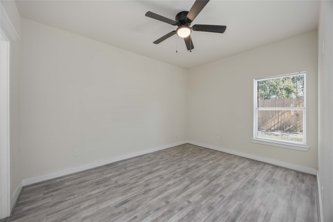 2708 Sam Wilson Street Houston, TX 77020 - Photo 11 of 18 an empty room with wooden floor chandelier fan and windows