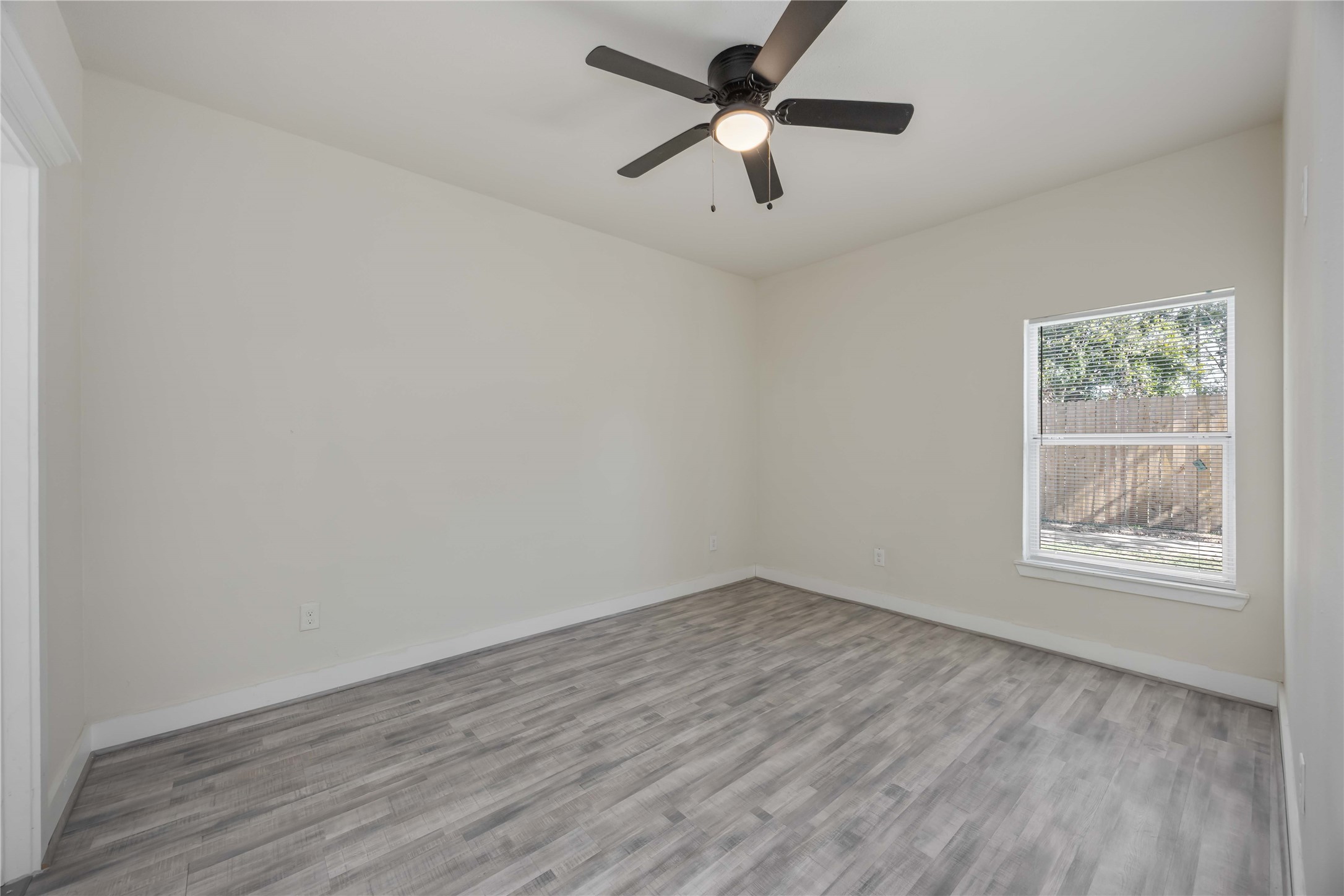 2708 Sam Wilson Street Houston, TX 77020 - Photo 11 of 18 an empty room with wooden floor chandelier fan and windows