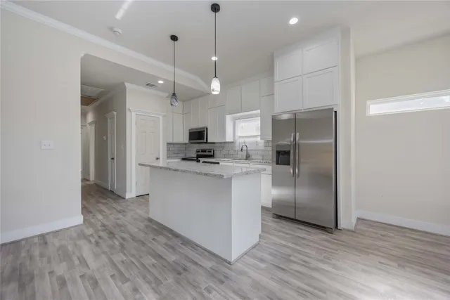 a kitchen with stainless steel appliances a refrigerator sink and microwave