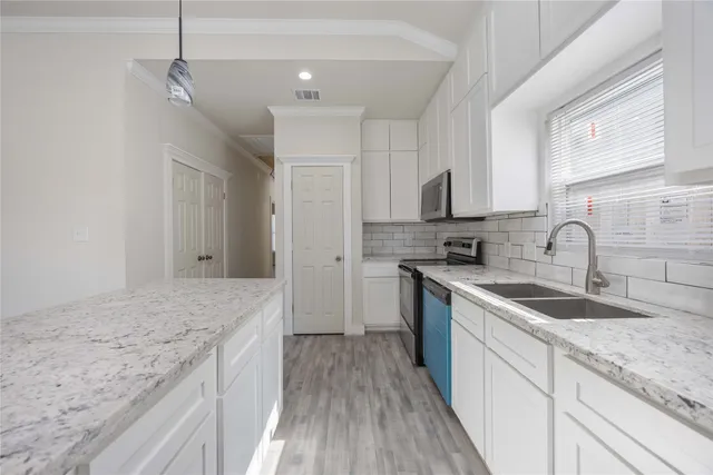 a kitchen with a sink stove and cabinets