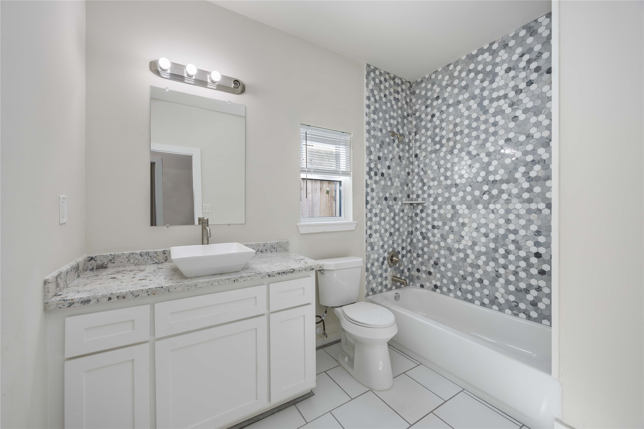 2708 Sam Wilson Street Houston, TX 77020 - Photo 7 of 18 a bathroom with a granite countertop sink a toilet and a bathtub