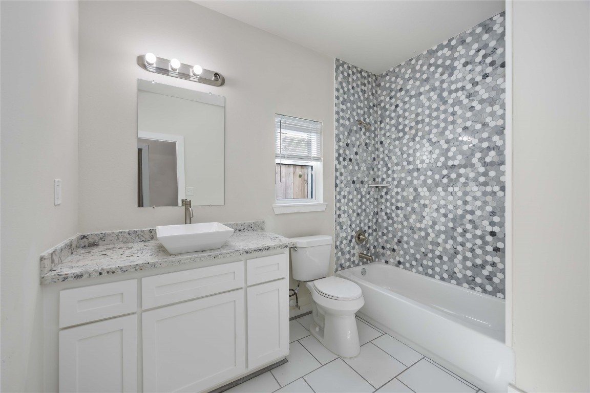 2708 Sam Wilson Street Houston, TX 77020 - Photo 7 of 18 a bathroom with a granite countertop sink a toilet and a bathtub
