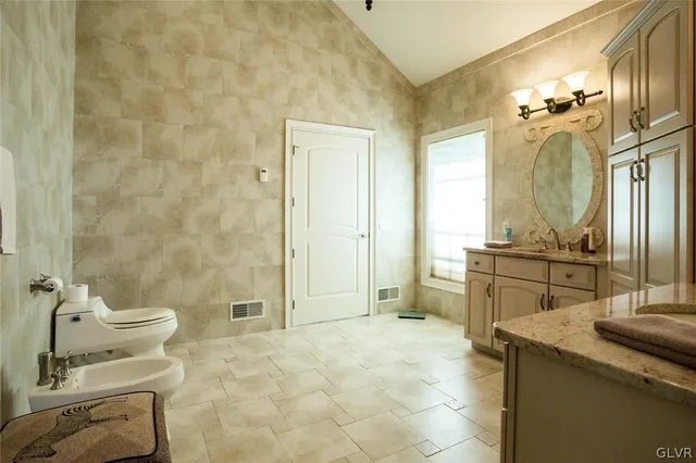 a bathroom with a granite countertop sink a toilet and shower