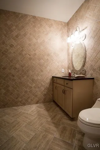 a bathroom with a granite countertop sink a toilet and a mirror