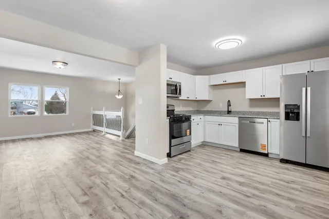 a kitchen with stainless steel appliances a refrigerator sink and cabinets