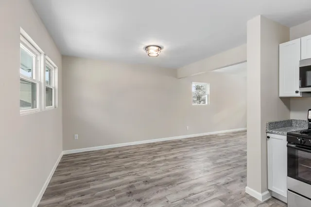 a view of kitchen and hallway with wooden floor