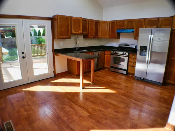 a kitchen with granite countertop a stove a sink and a refrigerator