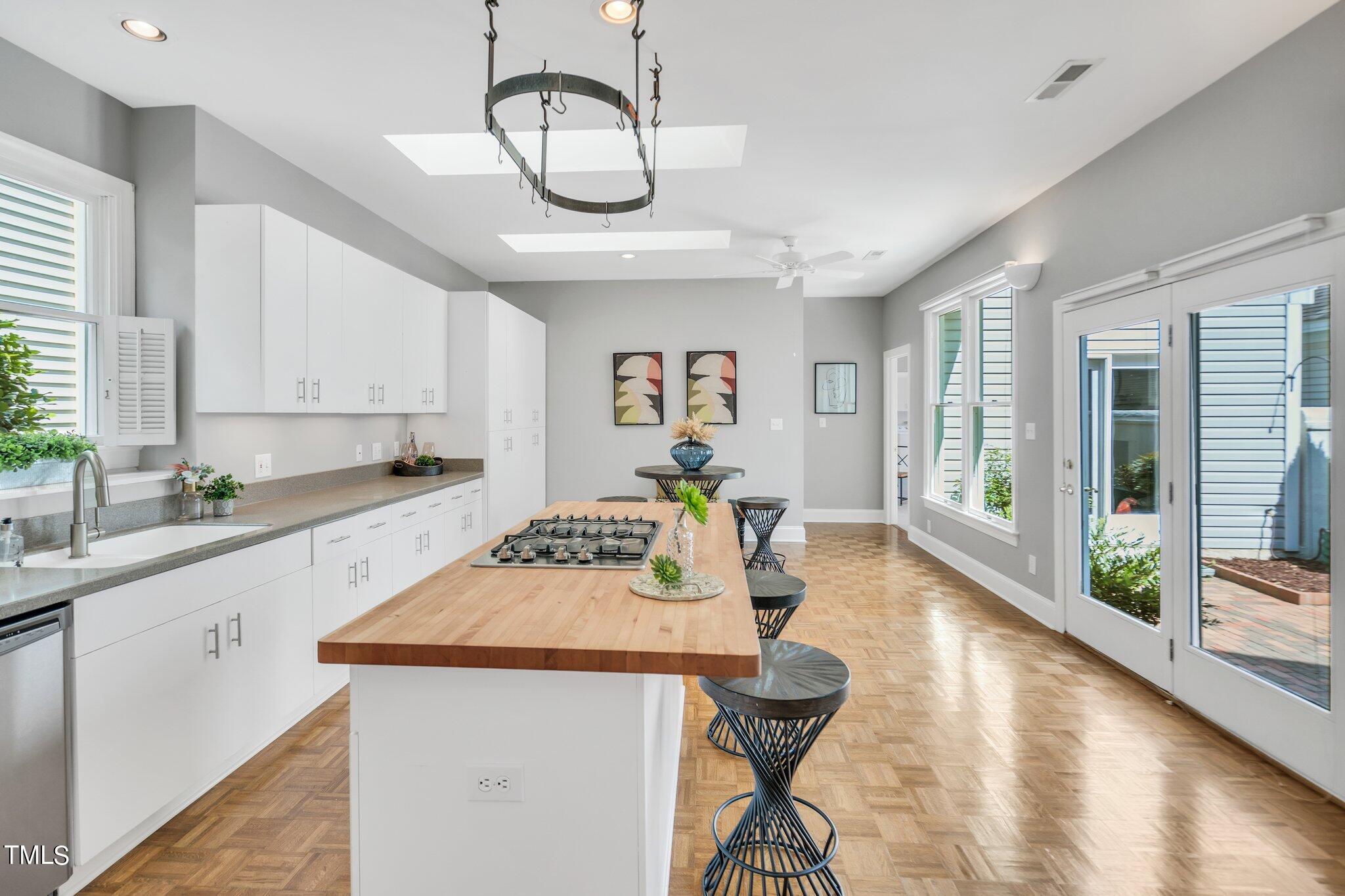 25 East Camden Pittsboro, NC 27312 - Photo 19 of 71 a open kitchen with stainless steel appliances granite countertop a stove top oven a sink a dining table and chairs with wooden floor