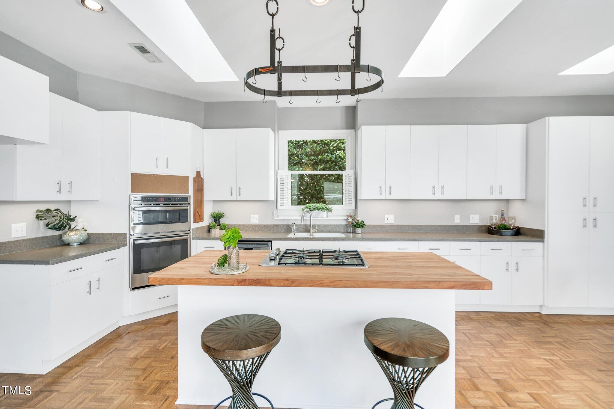 25 East Camden Pittsboro, NC 27312 - Photo 26 of 71 a kitchen with stainless steel appliances granite countertop a sink a stove a kitchen island with a dining table and chairs
