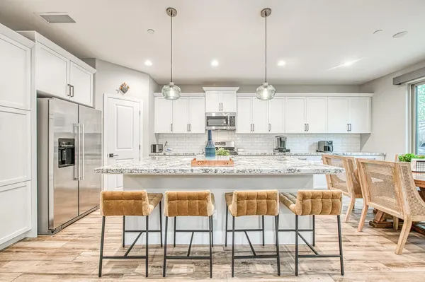 a kitchen with a table chairs and wooden floor