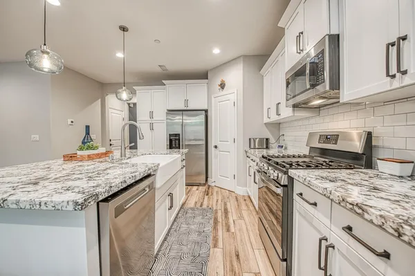 a large kitchen with stainless steel appliances granite countertop a stove and a sink