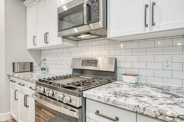 a view of a kitchen with kitchen island a sink a counter space and stainless steel appliances