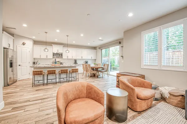 a living room with furniture a rug and kitchen view