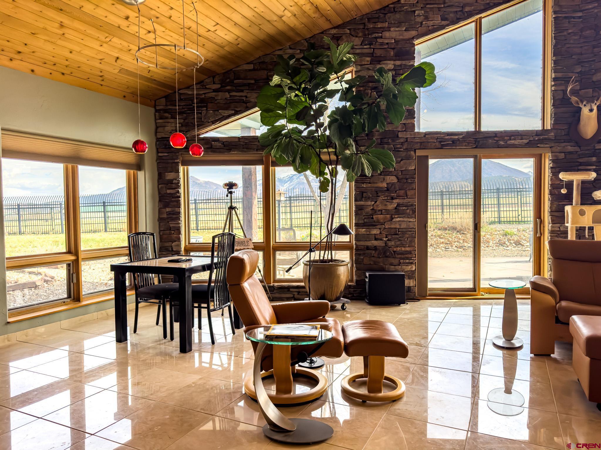 1071 Black Canyon Road Crawford, CO 81415 - Photo 18 of 36 a dining room with furniture large windows and wooden floor