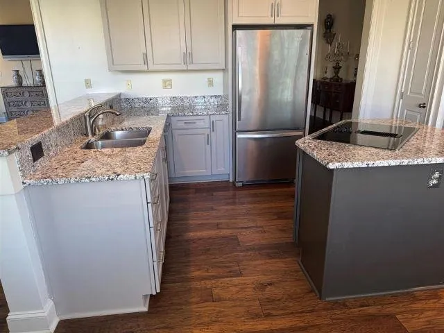 a kitchen with granite countertop a refrigerator and a sink