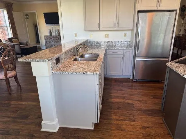 a kitchen with granite countertop a refrigerator and a stove