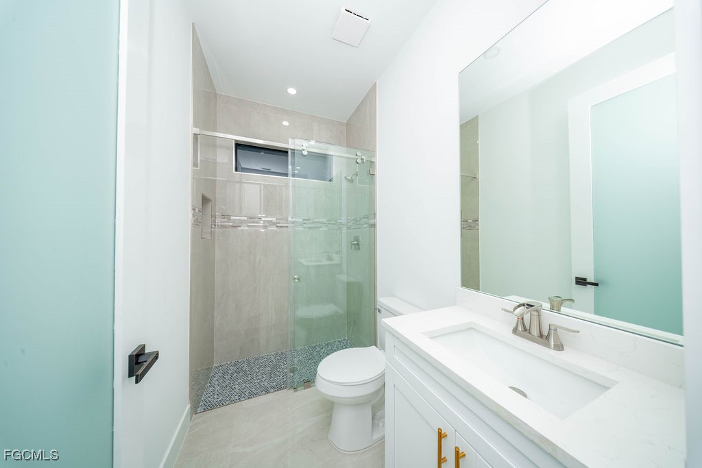 2819 34th Street West Lehigh Acres, FL 33971 - Photo 25 of 41 a bathroom with a granite countertop sink a toilet and shower