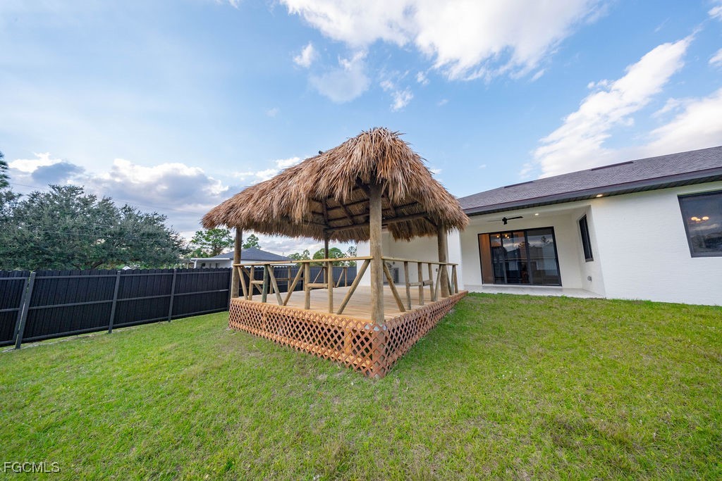 2819 34th Street West Lehigh Acres, FL 33971 - Photo 28 of 41 a view of a backyard with a garden and deck