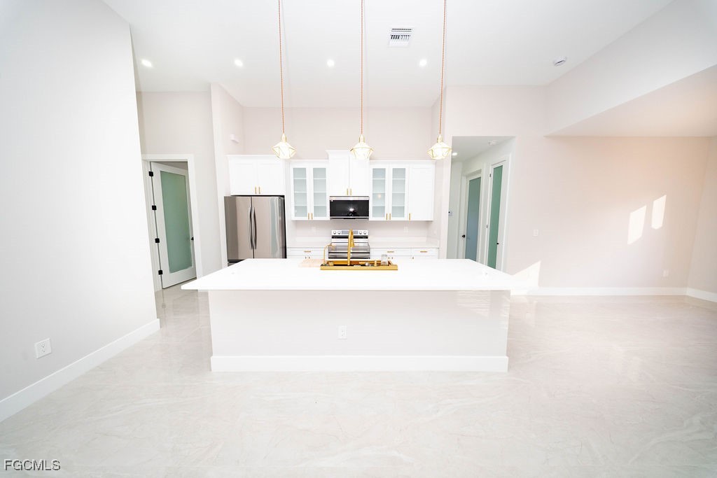 2819 34th Street West Lehigh Acres, FL 33971 - Photo 5 of 41 a view of kitchen with kitchen island stainless steel appliances sink refrigerator and microwave