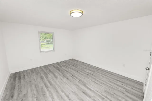 a view of a room with wooden floor and window