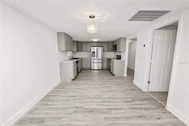 a view of a kitchen with a sink and dishwasher a refrigerator with wooden floor