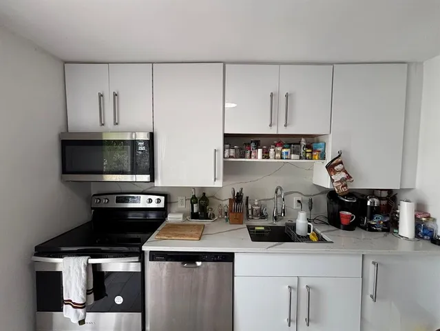 a kitchen with stainless steel appliances a sink a stove and cabinets