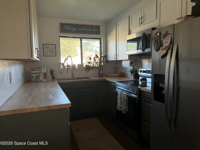 a kitchen with stainless steel appliances a refrigerator sink stove microwave and cabinets