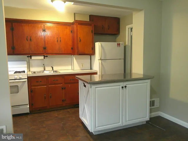 a kitchen with a refrigerator sink and cabinets