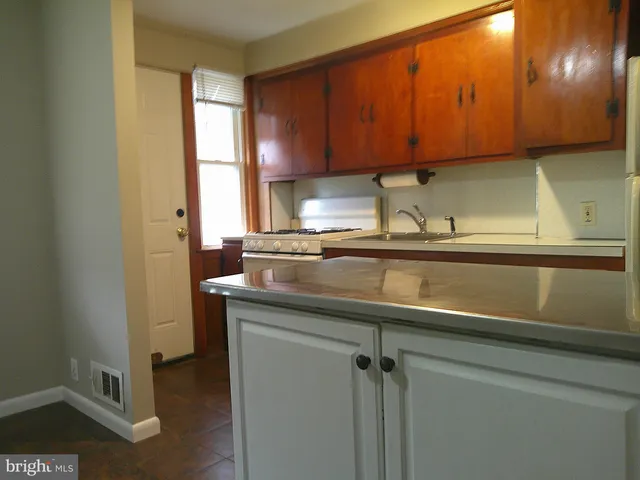 a kitchen with a sink a window and cabinets
