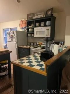 a kitchen with granite countertop a sink stove and cabinets