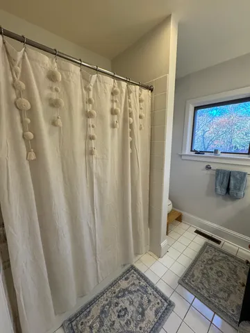 a bathroom with a shower curtain and a window