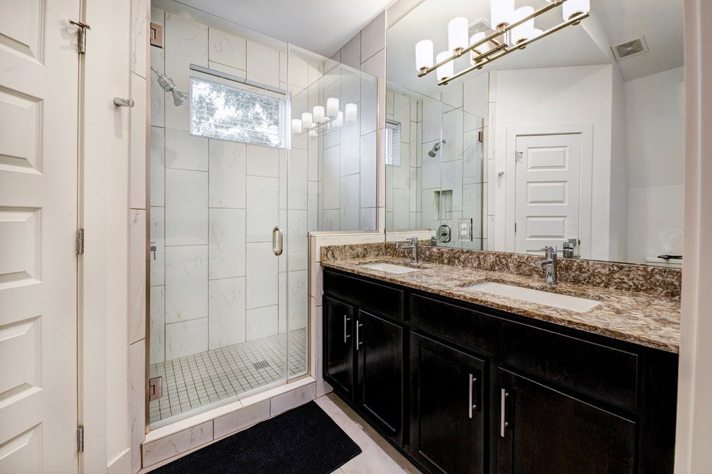 1300 Walnut Avenue, Unit B Austin, TX 78702 - Photo 13 of 15 a bathroom with a granite countertop sink a mirror and a shower