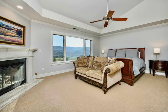 a bed sitting in a spacious bedroom next to a fireplace and window