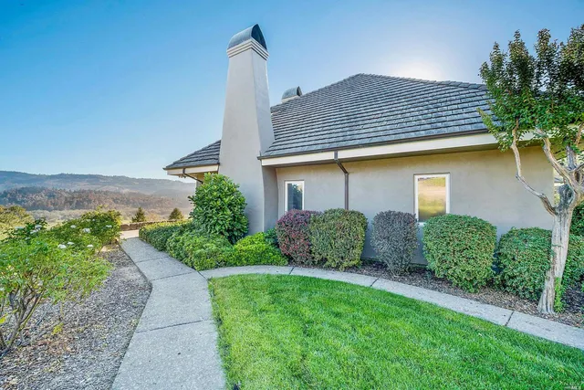 a view of a lush green field with mountains in the background