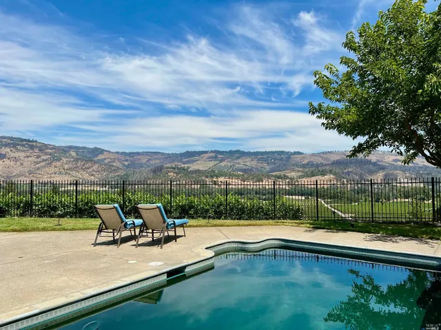 a view of a yard with a wooden fence