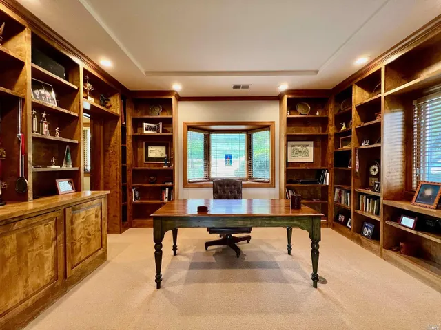 a view of a workspace with furniture and a bookshelf
