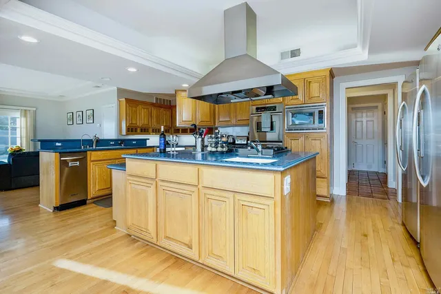 a kitchen with stainless steel appliances granite countertop a stove a sink and a refrigerator