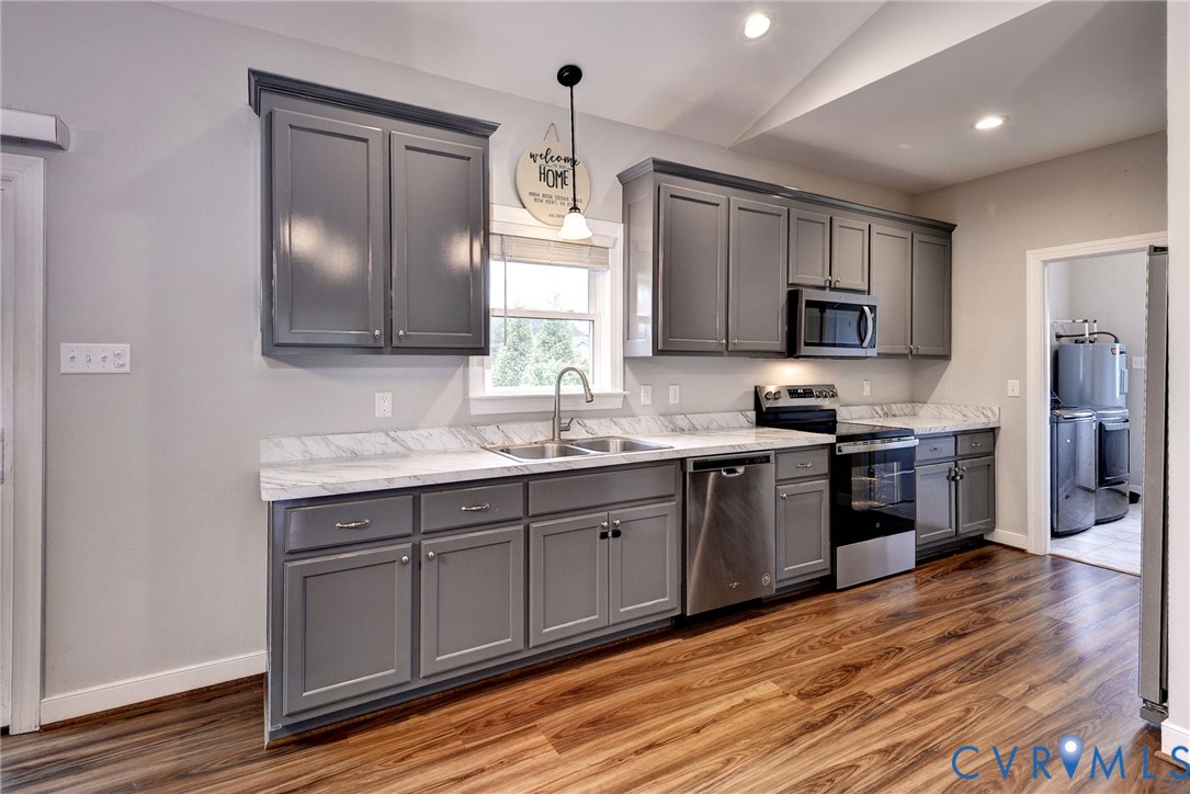 8904 Rock Cedar Road New Kent, VA 23124 - Photo 10 of 37 a kitchen with kitchen island granite countertop a sink cabinets and stainless steel appliances