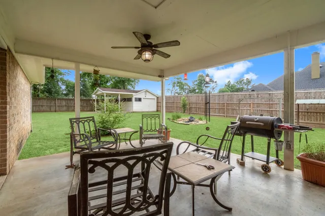 a view of a patio with a table chairs and a backyard
